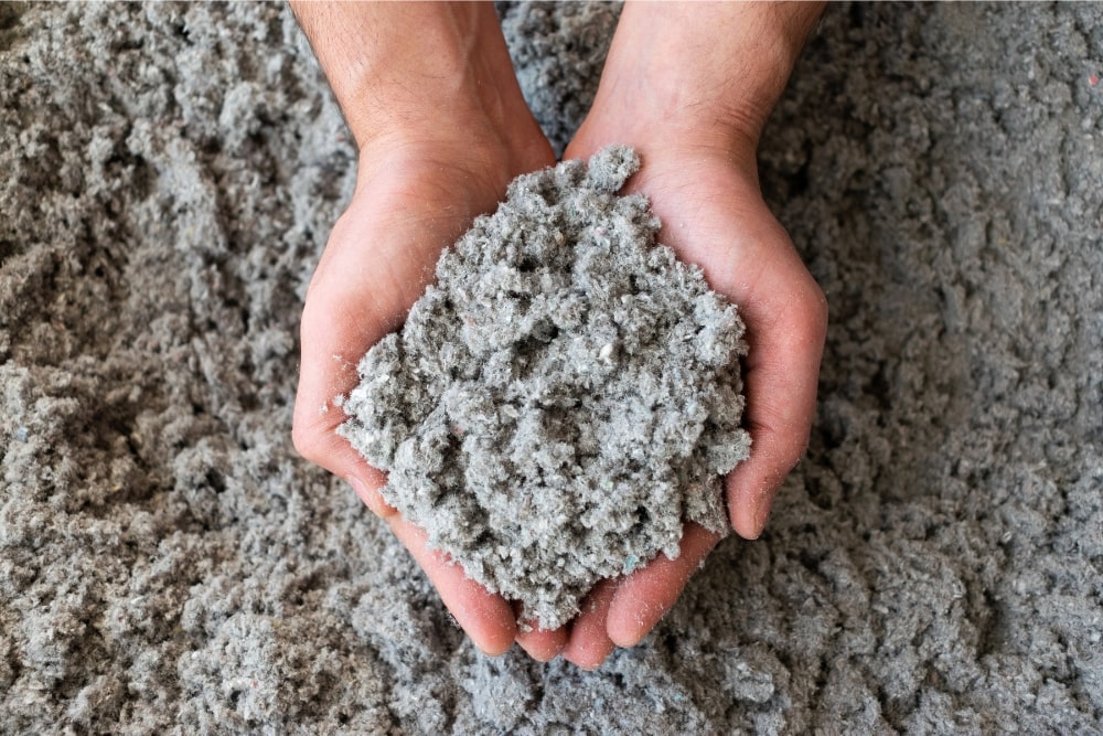 hands holding blow in insulation