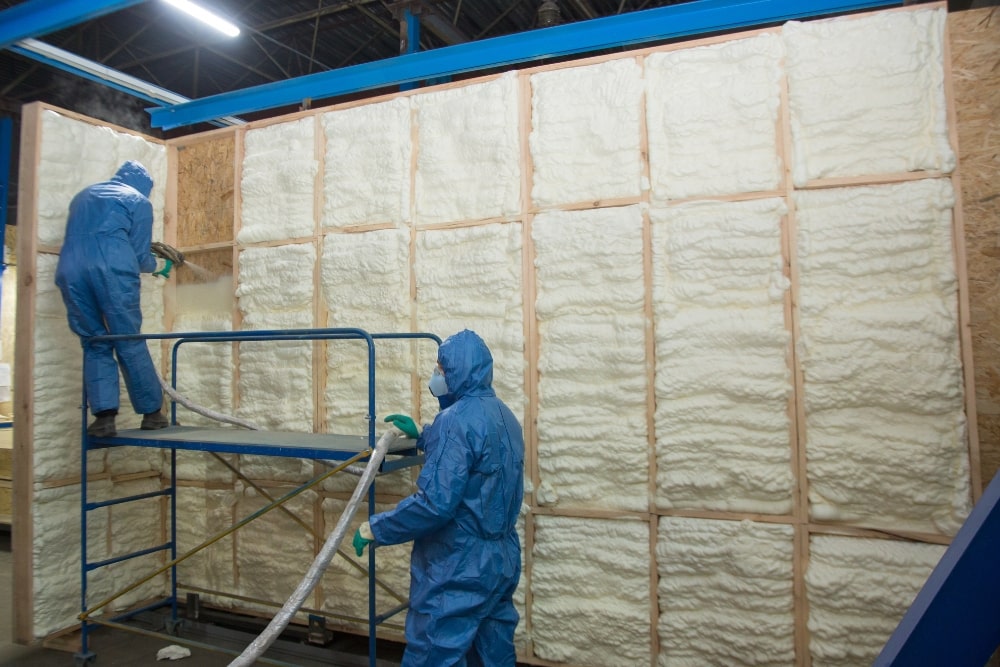 two men installing spray foam insulation